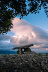 Dolmen called Chabola de la Hechicera with mountains in the background and clouds during sunset, in Alava, near Laguardia, Basque Country, Spain