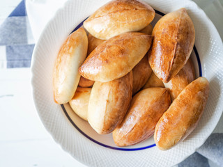 Russian yeast portioned cakes stuffed in white dish. Top view