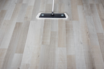 top view of modern mop cleaning wooden parquet floor at home