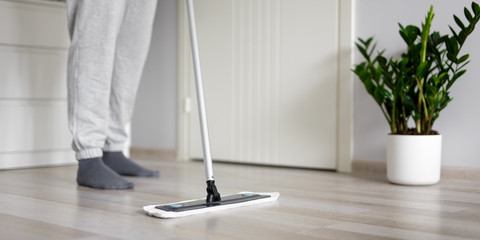 housewife washing wooden floor at home