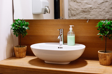 Fototapeta na wymiar Close up of a wash basin and liquid soap in a modern restroom