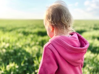 a toddler girl running in green wheat field