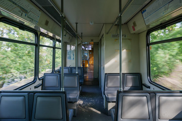 Fototapeta premium Interior view of a corridor inside passenger trains with old grey seats of German railway train system. Empty vacant passenger car inside the train. 