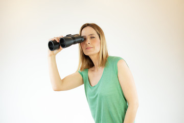 Woman in green shirt looking through binoculars