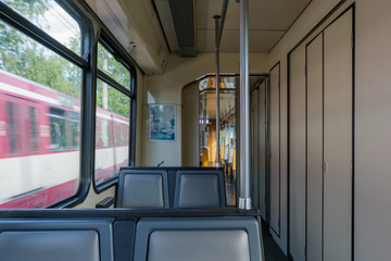 Interior view of a corridor inside passenger trains with old grey seats of German railway train system. Empty vacant passenger car inside the train.
