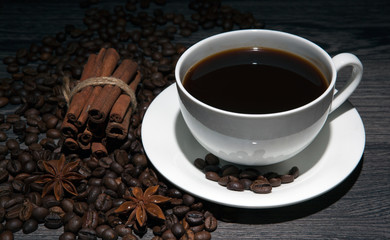 cup of hot coffee and roasted coffee beans on a wooden table