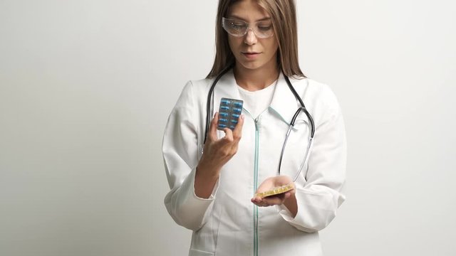 Female doctor holding treatment pills in front of the camera