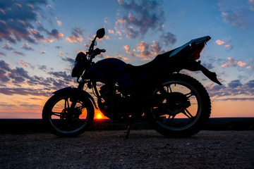 Obraz na płótnie Canvas Motorcycle side view on a beautiful sunset evening sky