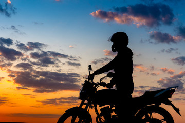 Naklejka na ściany i meble Motorcyclist enjoy At Sunset sky 