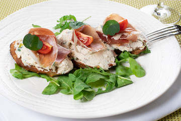 . Traditional Italian finger food canape, bruschetta with cream cheese and ham, fresh snack