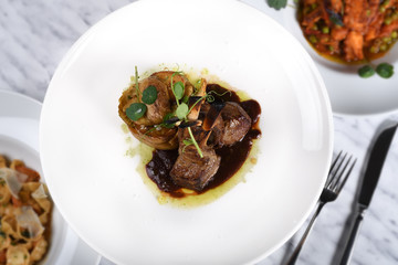 Lamb chops with baked baby potatoes and artichoke sauteed and red wine sauce . Traditional Italian