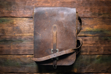 Old retro brown leather bag on the table flat lay background. - obrazy, fototapety, plakaty