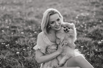 Close up portrait of smiling young attractive woman embracing spitz.