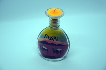 Custom homemade candle placed in a bottle along with creative sand art
