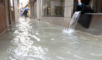 person emptying the interior of the shop flooded after the flood