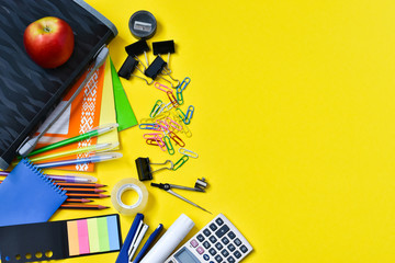 Concept back to school. Top view of colorful school supplies on a yellow background. Place for text