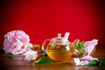 summer flower tea from rose petals in a glass teapot