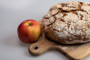 freshly baked bread isolated on wooden plate with apple