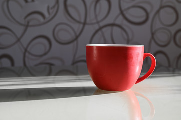 red cup with a shadow. Long shadow from a cup of coffee