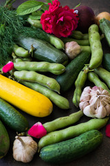 Fresh cucumbers, broccoli, cabbage, cauliflower, onions, garlic, zucchini, beans. A variety of vegetables are on the table.