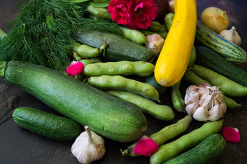 Fresh cucumbers, broccoli, cabbage, cauliflower, onions, garlic, zucchini, beans. A variety of vegetables are on the table.