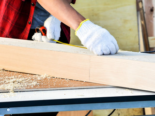 close up hands with white protective safety glove of  carpenter working on the wood work and live...