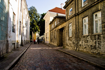 Fototapeta na wymiar A street with houses and a cobblestone road in the center of the old city in Tallinn, Estonia