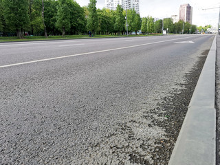 Fototapeta premium Lane for public transport. Poor quality of asphalt pavement in the city and new curbs. Empty roads in the city during quarantine.
