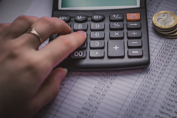There is a calculator and coins on the table