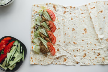 Cooking chicken roll with meat, fresh vegetables, herbs and sauce.