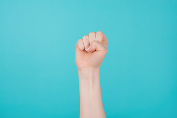 Girl power concept. Cropped photo of woman holding raising up a fist as a sign of triumph isolated...