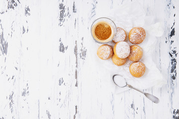 Obraz na płótnie Canvas Fresh fried mini donuts sprinkled with powdered sugar