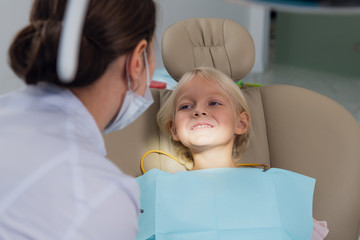 Image of a little girl ready to have her teeth checked by a doct