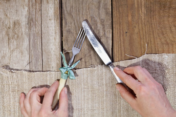 Cutlery in the hands of a woman on the background of a wooden texture.The concept of eating,diet