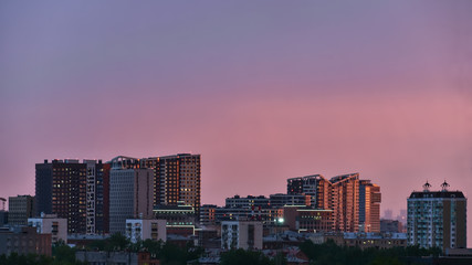 Naklejka premium The city is lit by the setting sun. City landscape.