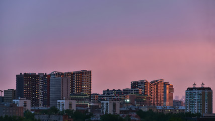 The city is lit by the setting sun. City landscape.