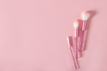 Makeup brushes on a pink background. Place for text