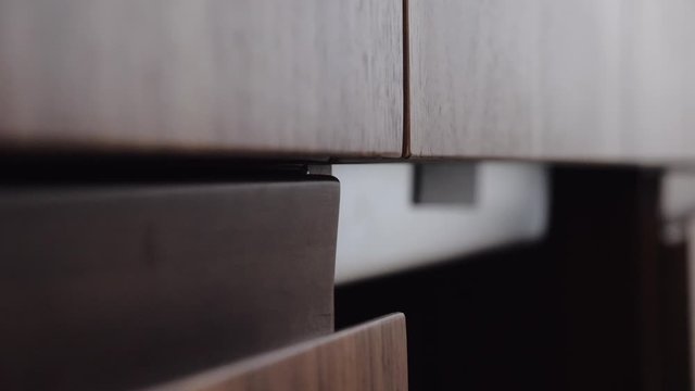 A man's hand opens the kitchen Cabinet door