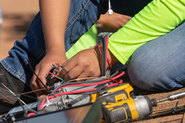 An electrical technician strips the plastic insulation from the ends of some wires in preparation for attaching the wire nuts.