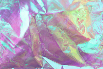 Blurred light rainbow crumpled holographic background.