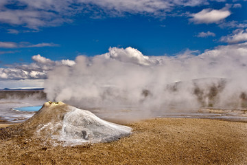 Beautiful colourful Icelandic landscape lava fields mountain geysers zigzag road and moss-covered stones Namafjall, Iceland.