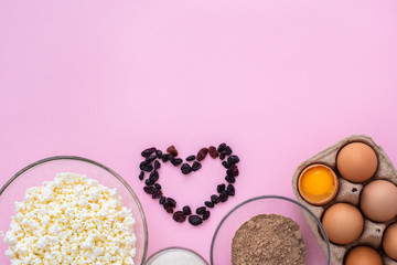 on a pink background, products for the preparation of casserole cottage cheese. Eggs, cottage cheese, raisins,sugar, flax  flour. a life. household chores. stay home. recipe. Copyspace. Flat lay