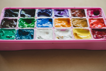 gouache paints in pink box on neutral background