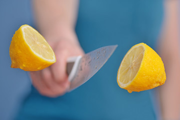 Yellow lemon. Slicing fruit with a knife in the air.	