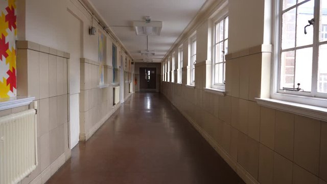 4K: Empty School or College Corridor with no people. The Long passage is deserted in this place of eductation. High Tracking Shot. Stock Video Clip Footage
