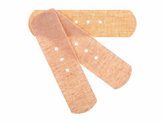 Top view of three beige adhesive bandages isolated on a white background