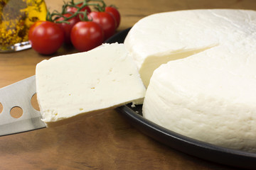 Slice of buffalo fresh cheese made in Serra da Canastra, in wood background