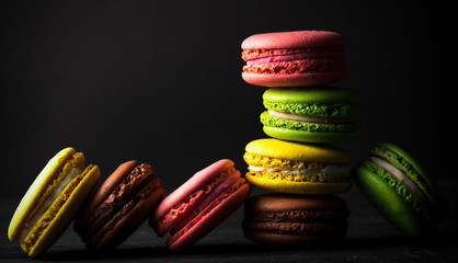 .colored macaroons on a black background