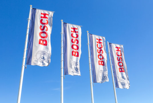 Flags with emblem Bosch against the blue sky