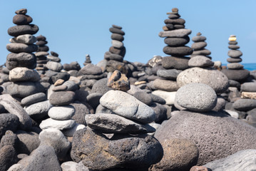 Fototapeta na wymiar Stone cairns on Puerto de la Cruz coast, Tenerife island, Spain